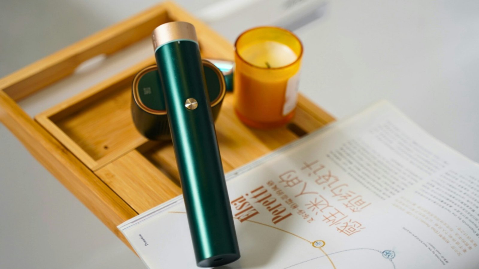 A pen sitting on top of a desk next to a candle